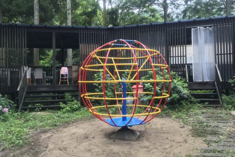 公園　回転ジャングルジム　中心軸と台が青　円形部分が赤と黄色のパイプ