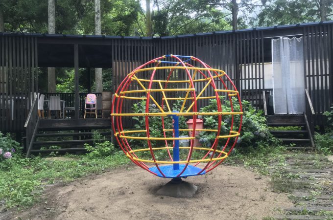 公園　回転ジャングルジム　中心軸と台が青　円形部分が赤と黄色のパイプ